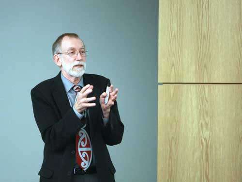 Insightful older man giving a presentation at UVU Review conference on education and innovation.